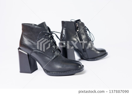 Women's boots with black genuine leather on heels isolated on a white background. photo from the side, diagonally and foreshortened from behind. Women's shoe collection 2022 Women's boots with black genuine leather on heels isolated on a white background. photo from the side, diagonally and foreshortened from behind. Women's shoe collection 2022 137887090