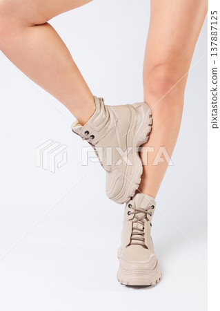 Female legs in beige leather shoes from the new collection on a white background female legs in fashionable shoes made of eco-leather spring 2022. Female legs in beige leather shoes from the new collection on a white background female legs in fashionable shoes made of eco-leather spring 2022. 137887125