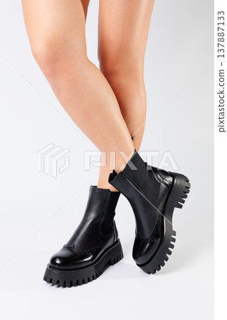 New collection of women's shoes spring 2022. girl's legs in new shoes. Legs in black boots. Low running boots made of genuine leather New collection of women's shoes spring 2022. girl's legs in new shoes. Legs in black boots. Low running boots made of genuine leather 137887133