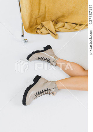 Women's leather shoes. Female legs in beige leather boots. Fashionable women's boots. 137887155