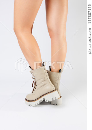 Women's white spring boots made of genuine leather are worn on a woman's leg. New collection of women's boots 2022 137887156