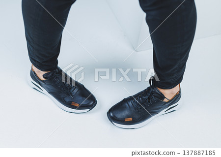 Men's legs in casual shoes of black color made of genuine leather, men on shoes in black sneakers. High quality photo Men's legs in casual shoes of black color made of genuine leather, men on shoes in black sneakers. High quality photo 137887185