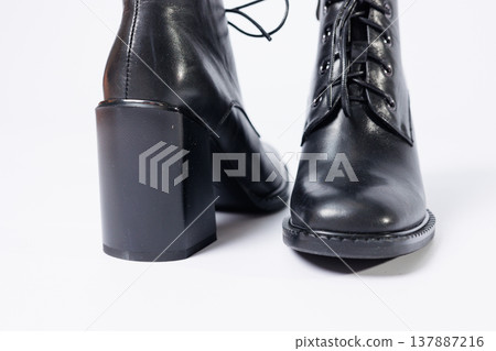 Women's boots with black genuine leather on heels isolated on a white background. photo from the side, diagonally and foreshortened from behind. Women's shoe collection 2022 Women's boots with black genuine leather on heels isolated on a white background. photo from the side, diagonally and foreshortened from behind. Women's shoe collection 2022 137887216