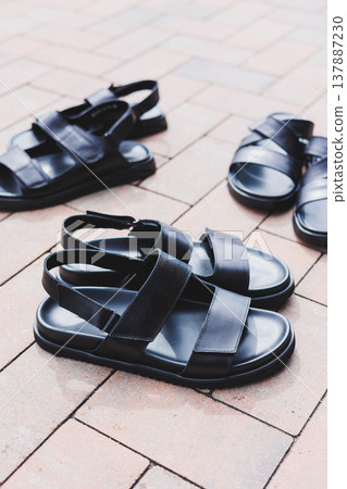 Men's black leather sandals stand on an isolated background. Summer collection of men's shoes Men's black leather sandals stand on an isolated background. Summer collection of men's shoes 137887230