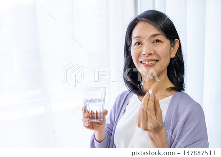 老婦人在窗邊吃藥 老婦人在窗邊吃藥 137887511