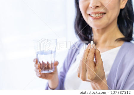 老婦人在窗邊吃藥 137887512