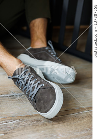 Male legs in gray casual sneakers. Comfortable men's summer shoes. 137887559