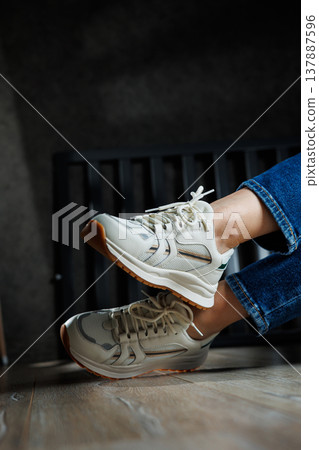 Collection of women's leather shoes. Female legs in leather white casual sneakers. Stylish women's sneakers 137887596