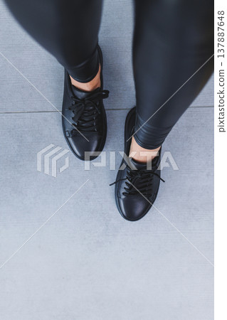 New collection of women's leather shoes, female legs close-up in black lace-up sneakers. Shoes for spring and summer 137887648