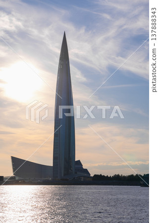 Tall skyscraper rises above the waterfront at sunset. Saint petersburg, Russia Tall skyscraper rises above the waterfront at sunset. Saint petersburg, Russia 137888343