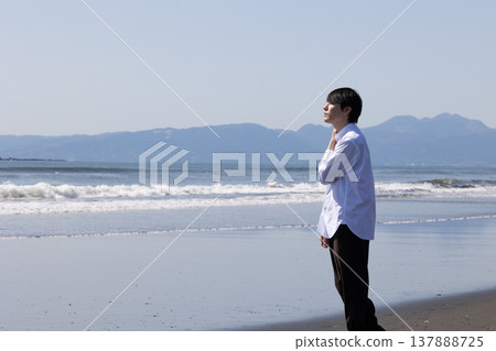一個男人站在水邊。 一個男人站在水邊。 137888725