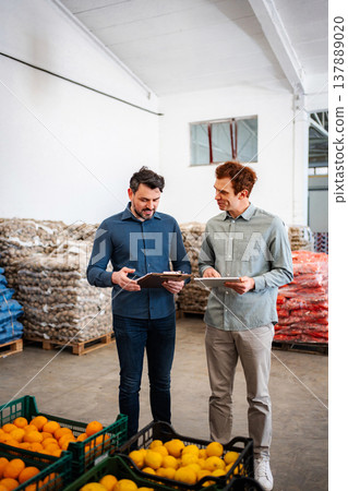 Colleagues analyzing inventory in a fresh produce warehouse 137889020