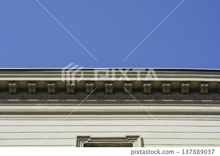 Classical Cornice with Dentil Molding against Blue Sky 137889037