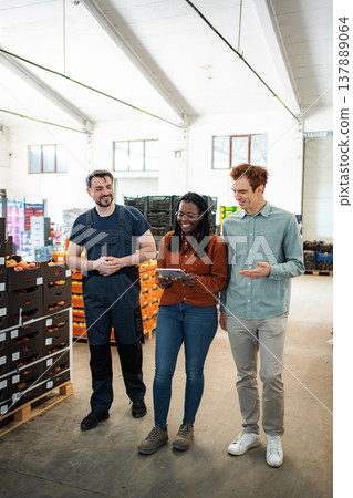 Warehouse workers collaborating on logistics using tablet technology 137889064