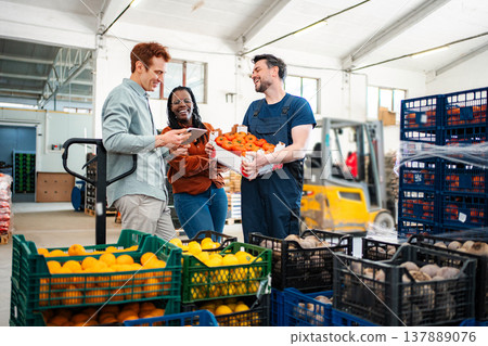 Diverse business people managing fresh produce logistics in warehouse Diverse business people managing fresh produce logistics in warehouse 137889076