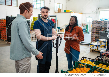 Warehouse workers discussing logistics and fresh produce distribution Warehouse workers discussing logistics and fresh produce distribution 137889083