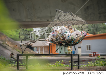 The concept of collecting household garbage and plastic waste is a fish sculpture made of wire mesh and filled with plastic garbage and waste. This installation expresses the concept of environmental The concept of collecting household garbage and plastic waste is a fish sculpture made of wire mesh and filled with plastic garbage and waste. This installation expresses the concept of environmental 137889228