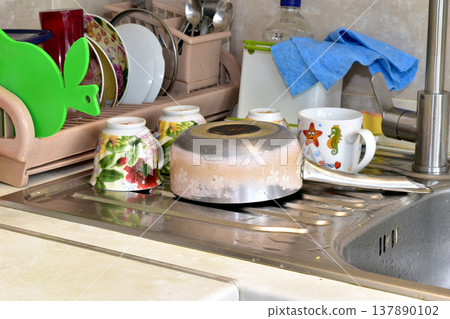 Clean dishes dry on the sink. Clean dishes dry on the sink. 137890102