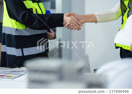 architects and engineers shake hands while working for teamwork. architects and engineers shake hands while working for teamwork. 137890406