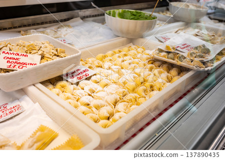 Genoa, liguria, italy. May 18, 2024. Freshly made ravioli and tortellini on display at a pasta stall in mercato orientale, offering traditional italian culinary products Genoa, liguria, italy. May 18, 2024. Freshly made ravioli and tortellini on display at a pasta stall in mercato orientale, offering traditional italian culinary products 137890435