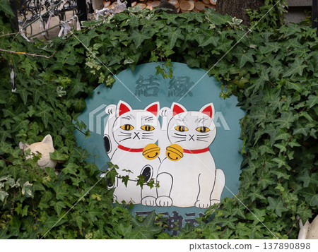 Imado Shrine, a sign featuring a lucky cat for matchmaking, Tokyo. 137890898