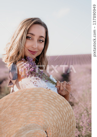 Woman lavender field straw hat posing in blooming purple meadow during golden hour sunset for travel and beauty concept 137890949