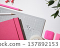 Stationery background with cutting mat, pink notebook, pencils, pen on white desk. Copyspace. 137892153