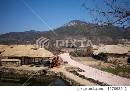 Curved pathway and traditional village with waterwheel in Nagan Eupseong, South Korea Curved pathway and traditional village with waterwheel in Nagan Eupseong, South Korea 137892342