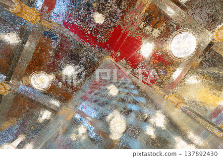 Mirror mosaic ceiling inside a temple with multiple light fixtures creating a reflective surface that forms bright patterns and detailed architectural design. Mirror mosaic ceiling inside a temple with multiple light fixtures creating a reflective surface that forms bright patterns and detailed architectural design. 137892430