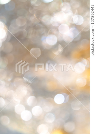 Golden bokeh lights with blurred circular highlights and warm tone creating an abstract light pattern suitable for luxury background use. 137892442