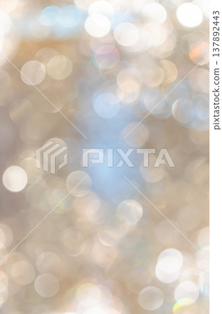 Golden bokeh lights with blurred circular highlights and warm tone creating an abstract light pattern suitable for luxury background use. 137892443