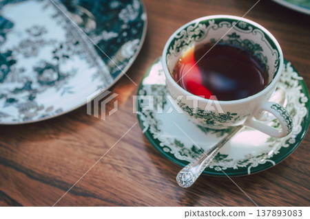 一隻經典的茶杯和一杯茶擺放在木桌上。 137893083
