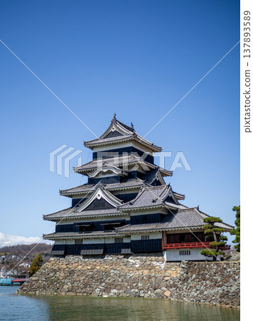 Matsumoto Castle stands tall against a clear blue sky. 137893589