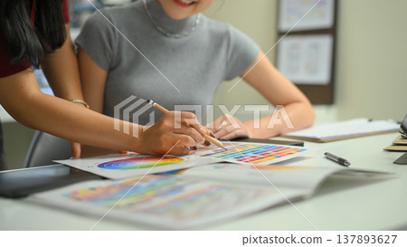 Cropped shot two graphic design desk sharing idea and creative with color on the desk 137893627
