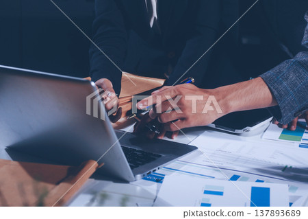 Professional photo of a person's hands reviewing a contract or legal document on a desk, for concepts of business, finance, and legal affairs 137893689