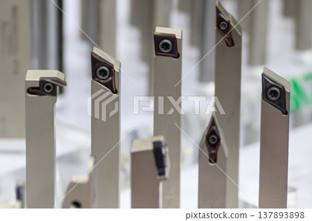 Close-up of a group of professional CNC turning tools and indexable carbide inserts for high-precision lathe machining. 137893898