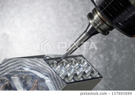 Advanced 5-axis CNC milling machine using a solid ball nose end mill to cut a high-performance V8 aluminum engine block. 137893899