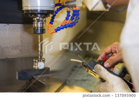 Close-up of a CNC milling machine operator setting up the tool length offset value for precision machining preparation. 137893900
