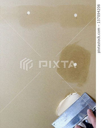 修補石膏板上的螺絲孔:膩子處理前後的牆面表面及施工圖。 修補石膏板上的螺絲孔:膩子處理前後的牆面表面及施工圖。 137894206
