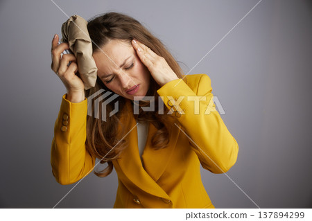 Businesswoman Relieving a Migraine with Ice Pack 137894299