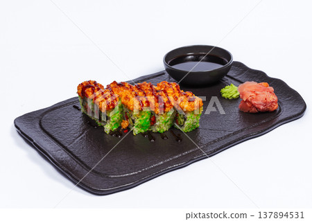 Avocado Topped Roll On Black Tray With Bright Green Slices, Fiery Topping, Sesame Crunch, Wasabi Soy Avocado Topped Roll On Black Tray With Bright Green Slices, Fiery Topping, Sesame Crunch, Wasabi Soy 137894531