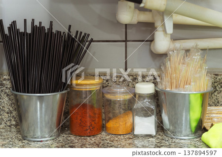 Black Chopsticks And Spice Jars On Granite Countertop In Sushi Kitchen Photoshoot, Organized Black Chopsticks And Spice Jars On Granite Countertop In Sushi Kitchen Photoshoot, Organized 137894597