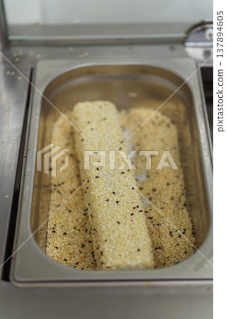 Panko Coated Fillets Resting In Stainless Pan, Breadcrumb Crust Flecked With Sesame, Organized Mise Panko Coated Fillets Resting In Stainless Pan, Breadcrumb Crust Flecked With Sesame, Organized Mise 137894605