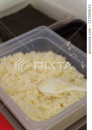 Plastic Container Filled With Sushi Rice And Scoop, Portion Ready For Service, Clear Lid Nearby, 137894631