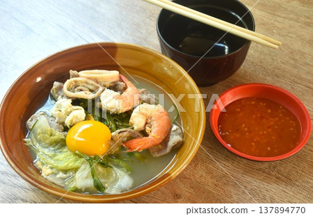 boiled sukiyaki seafood chicken and pork meat couple squid and shrimp with vegetable in soup on bowl dipping sauce boiled sukiyaki seafood chicken and pork meat couple squid and shrimp with vegetable in soup on bowl dipping sauce 137894770