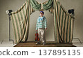 Young boy standing with violin and bow in studio minimal theatrical setup. 137895135