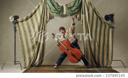 Teen boy playing cello energetically on stage expressive classical music performance. 137895145