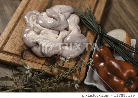 Cow bowels presented on a wooden board with ingredients, ready to grill 137895159