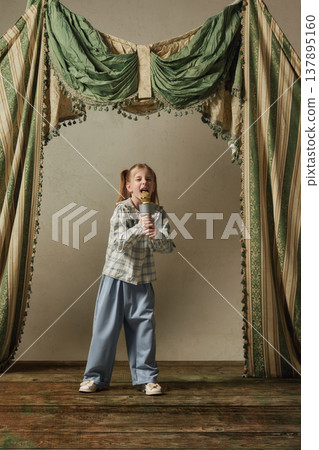Little girl singing into microphone on stage childhood performance music vocal. Little girl singing into microphone on stage childhood performance music vocal. 137895160