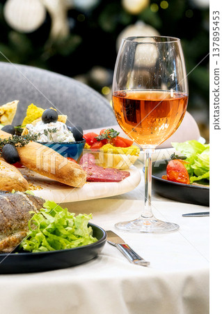 glass of rose wine with appetizers in background glass of rose wine with appetizers in background 137895453